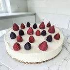 Decorative cake with hand poured strawberries, blackberries and raspberries soy wax birthday candles on a marble surface