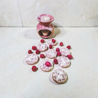 Waffle-shaped soy wax melts with pink icing and raspberry detailing arranged on a light surface